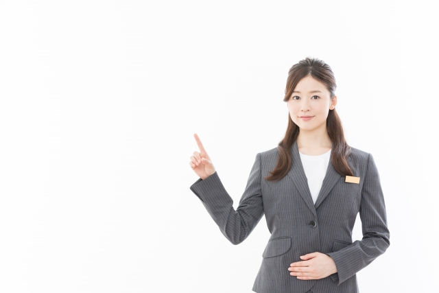 指を立てるスーツの女性
